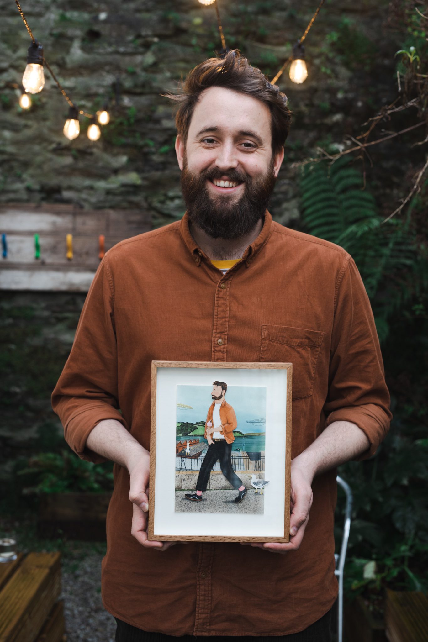 Liam holding portrait by artist Bex Bourne