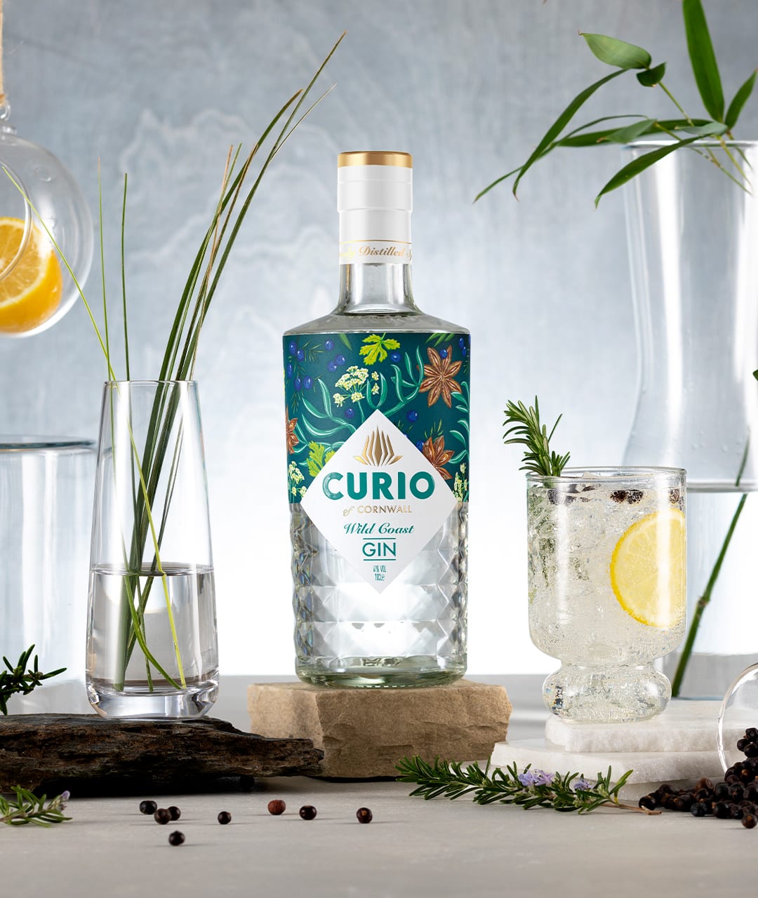 Curio wild coast gin bottle amongst garnishes and glassware